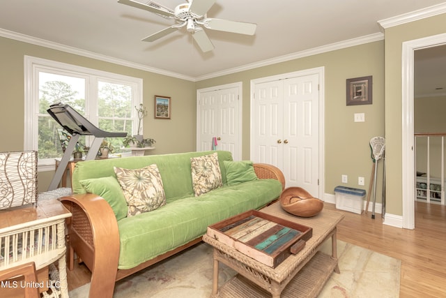 living room featuring light hardwood / wood-style floors, crown molding, and ceiling fan