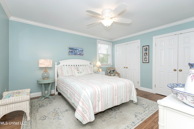 bedroom featuring crown molding, two closets, wood-type flooring, and ceiling fan