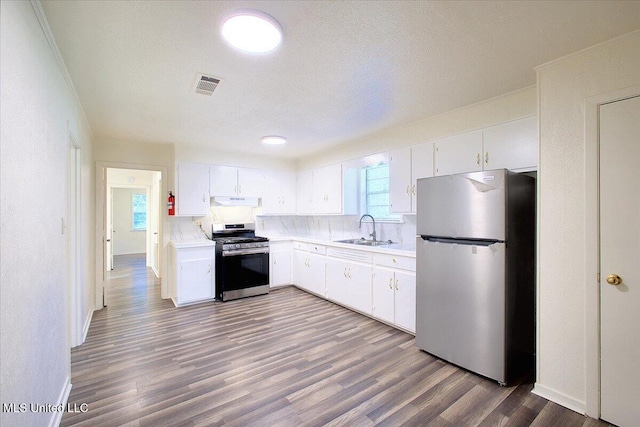 kitchen with white cabinetry, stainless steel appliances, wood-type flooring, and sink