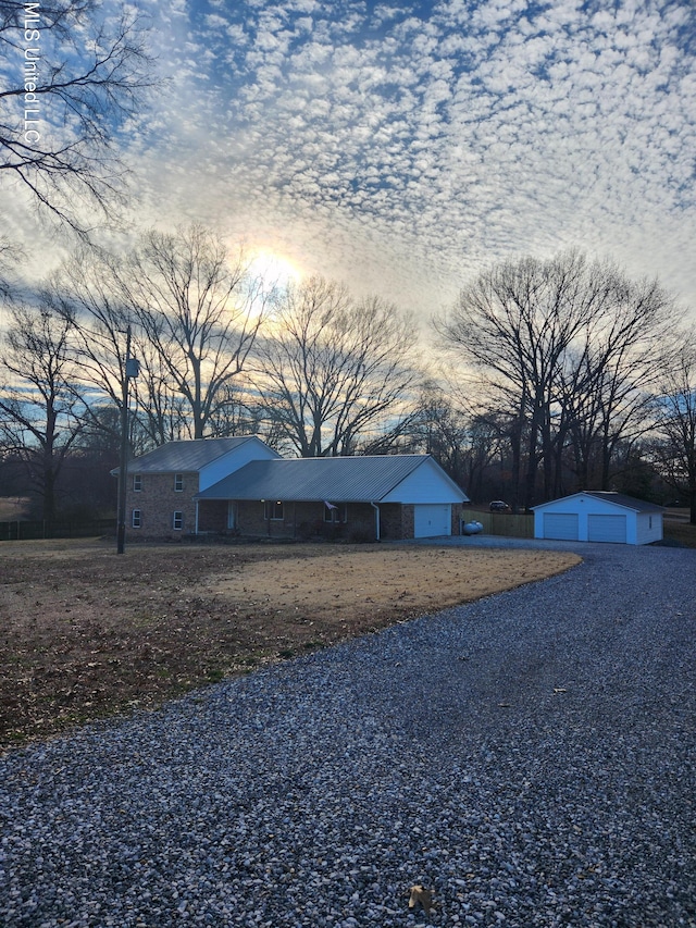 property exterior at dusk featuring a garage and an outdoor structure