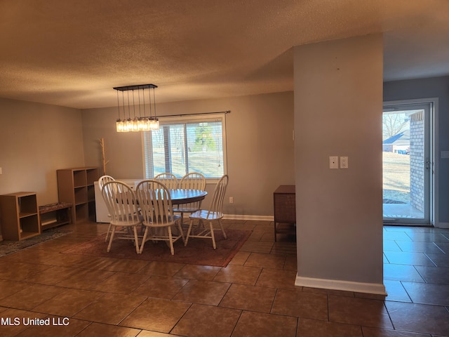 dining room featuring dark tile patterned flooring and a textured ceiling