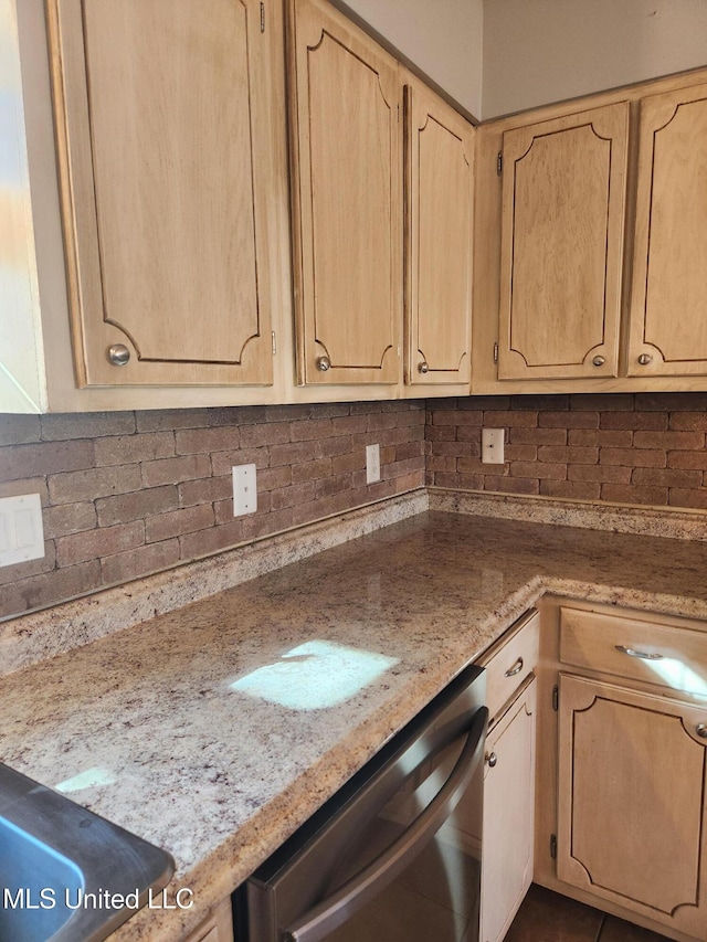 kitchen with stainless steel dishwasher, backsplash, and light brown cabinetry