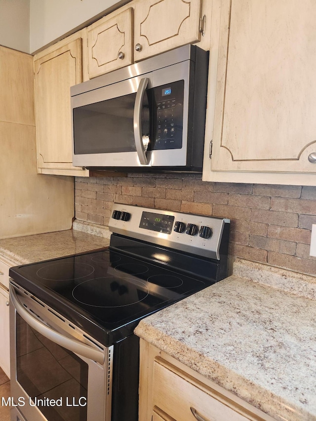 kitchen with stainless steel appliances and backsplash