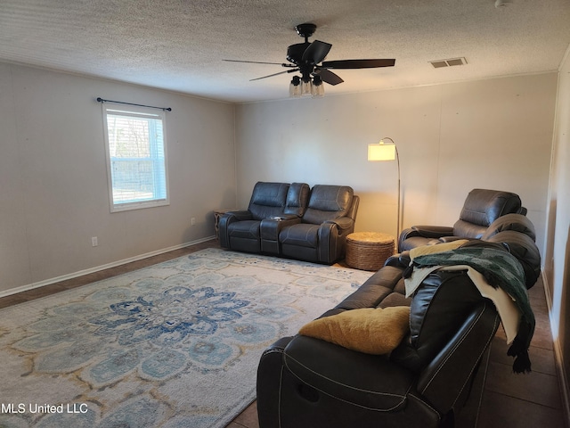 living room featuring ceiling fan and a textured ceiling