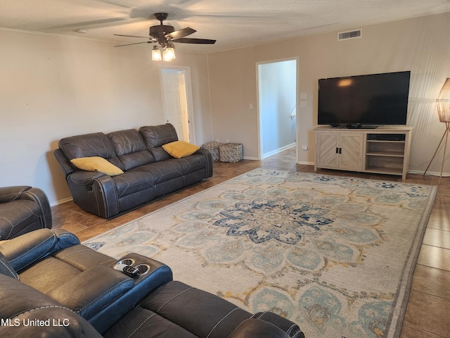 living room featuring ceiling fan and a textured ceiling