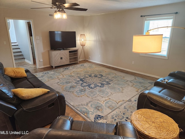 living room with a textured ceiling and ceiling fan