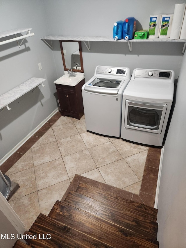 clothes washing area featuring cabinets, sink, washing machine and dryer, and light tile patterned floors