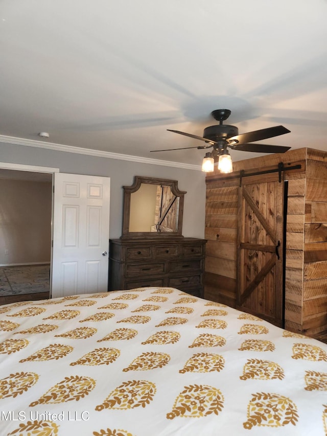 bedroom featuring ornamental molding, a barn door, and ceiling fan