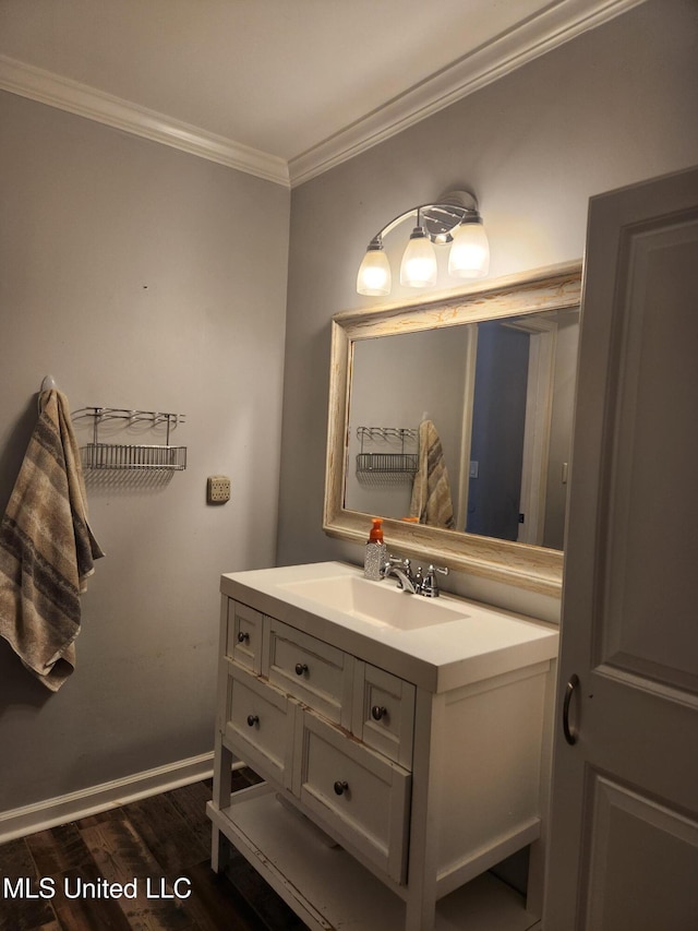 bathroom with ornamental molding, wood-type flooring, and vanity