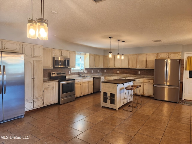 kitchen with sink, a kitchen island, pendant lighting, stainless steel appliances, and backsplash