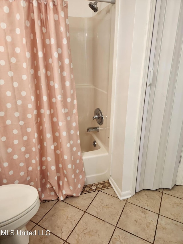 bathroom with toilet, tile patterned flooring, and shower / bath combo