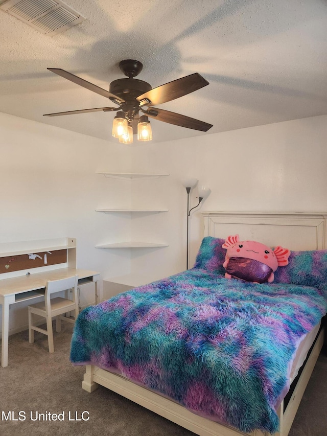 bedroom with a textured ceiling, ceiling fan, and dark colored carpet