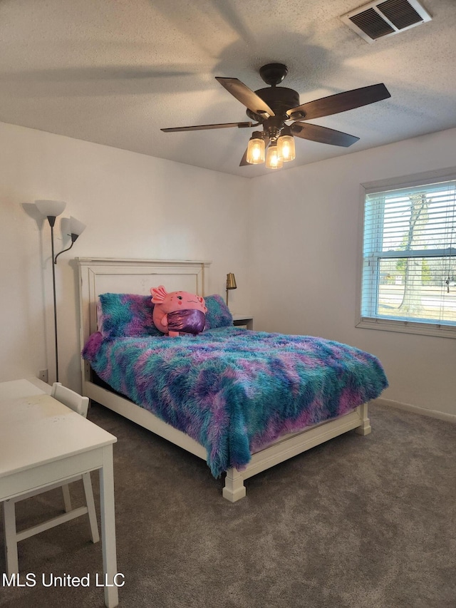 carpeted bedroom featuring ceiling fan and a textured ceiling