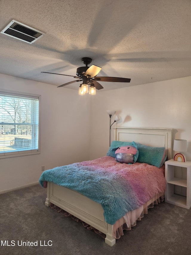 bedroom with dark carpet, a textured ceiling, and ceiling fan