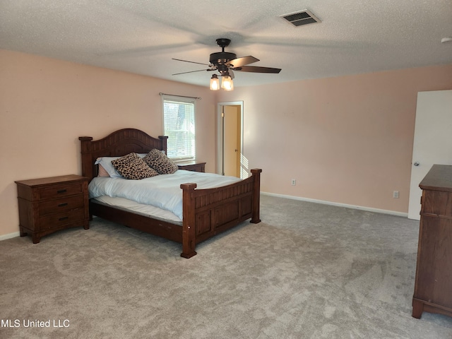 carpeted bedroom featuring a textured ceiling and ceiling fan