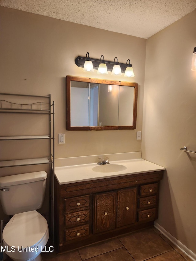 bathroom featuring vanity, tile patterned floors, a textured ceiling, and toilet