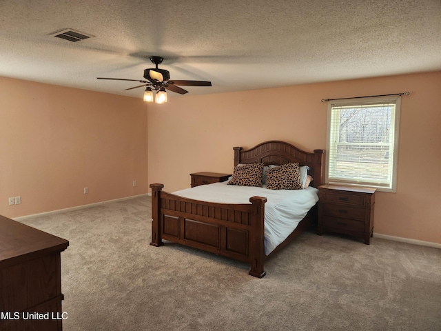 carpeted bedroom featuring a textured ceiling and ceiling fan