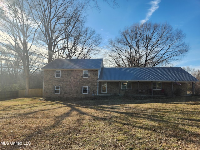 rear view of house featuring a yard