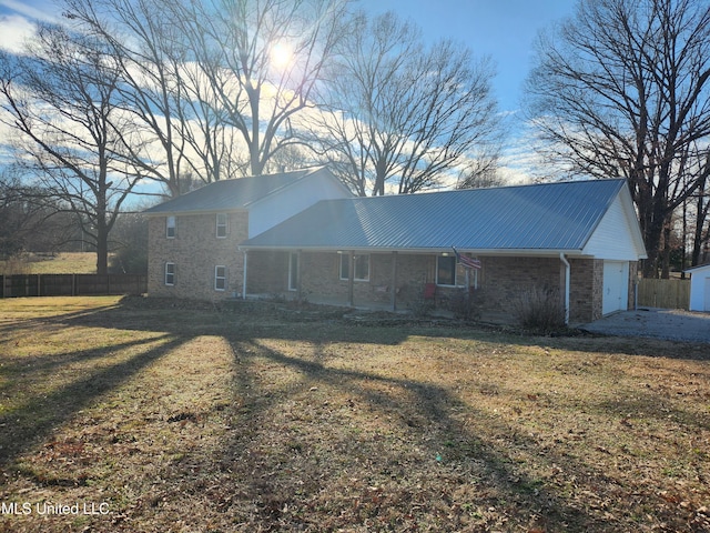 back of property with a garage and a yard