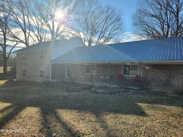 back of property with a yard and a patio area