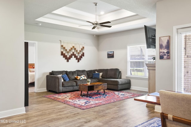 7380 Shearwater Way, Ocean Springs, MS 39564 - living room featuring ornamental molding, wood finished floors, healthy amount of natural light, baseboards, and a tray ceiling