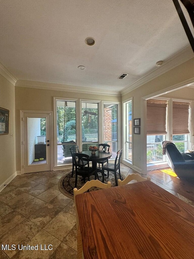 unfurnished dining area featuring a textured ceiling and crown molding