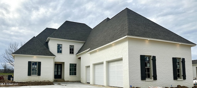 view of front of home featuring roof with shingles and driveway