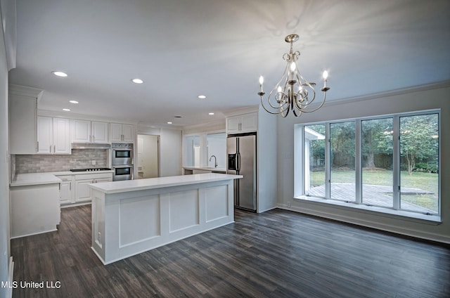 kitchen featuring a kitchen island, dark wood-type flooring, white cabinets, pendant lighting, and appliances with stainless steel finishes