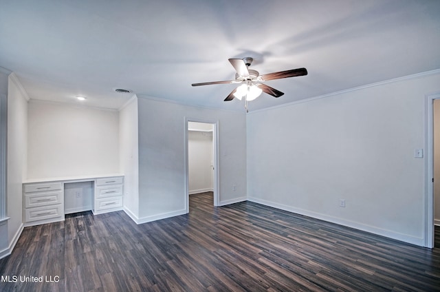 interior space with a spacious closet, ceiling fan, built in desk, and dark hardwood / wood-style floors