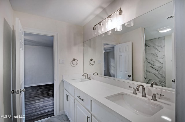 bathroom featuring vanity, a tile shower, and hardwood / wood-style flooring