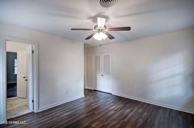 unfurnished bedroom featuring a closet, ceiling fan, and dark hardwood / wood-style flooring