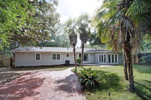 rear view of house with a patio, central AC unit, and a lawn