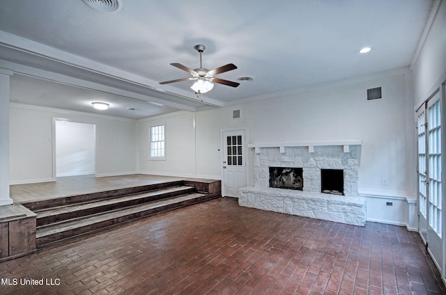 unfurnished living room featuring crown molding, a fireplace, and ceiling fan