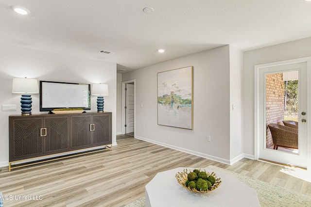 interior space with a textured ceiling and light wood-type flooring