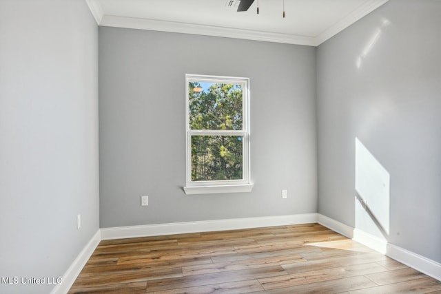 unfurnished room featuring plenty of natural light, ornamental molding, and light wood-type flooring