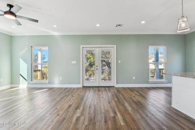 unfurnished living room featuring hardwood / wood-style flooring, ceiling fan, crown molding, and french doors