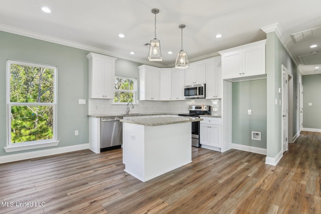 kitchen featuring white cabinetry, light stone counters, dark hardwood / wood-style flooring, a kitchen island, and appliances with stainless steel finishes