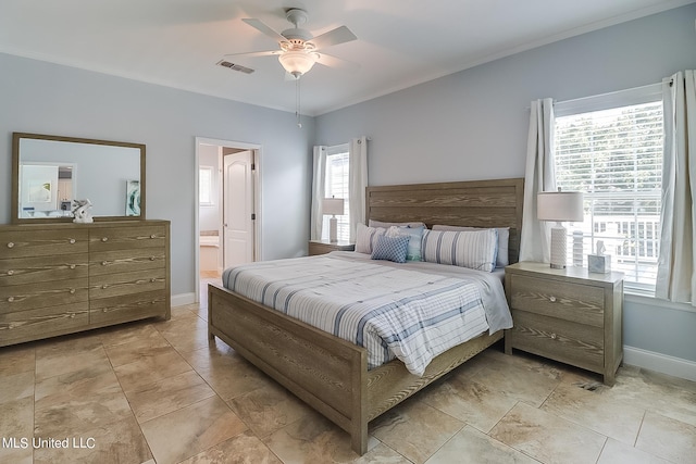 bedroom with ceiling fan, multiple windows, and ensuite bath