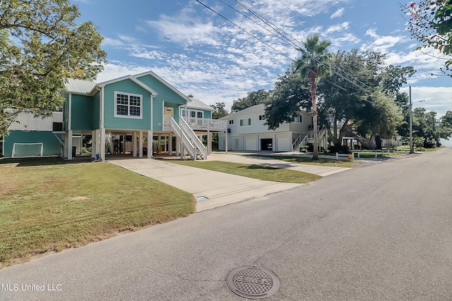 112 Vista Dr, Pass Christian, MS 39571 - raised beach house featuring driveway, metal roof, a front yard, a carport, and stairs