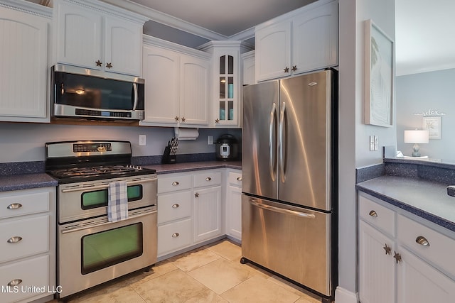 kitchen with appliances with stainless steel finishes, crown molding, white cabinets, and light tile patterned floors