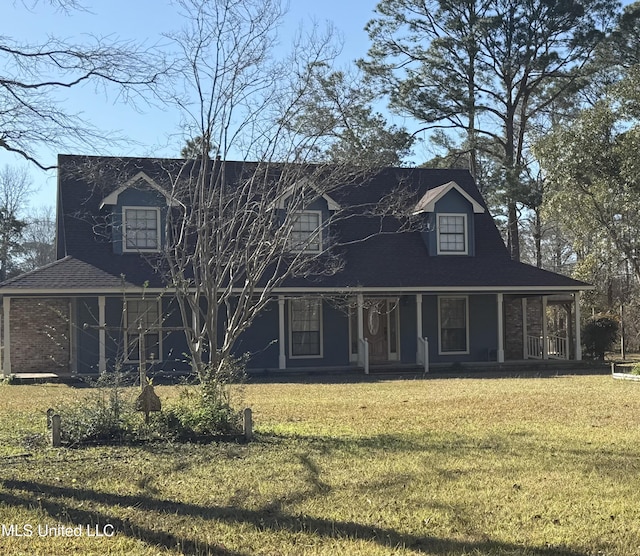 view of front of property featuring covered porch, roof with shingles, and a front lawn