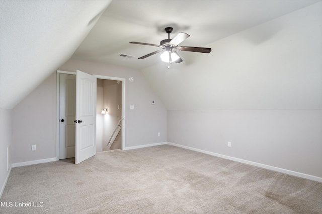 bonus room with light colored carpet, lofted ceiling, baseboards, and a ceiling fan