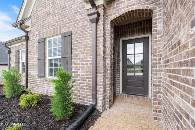 view of exterior entry with brick siding