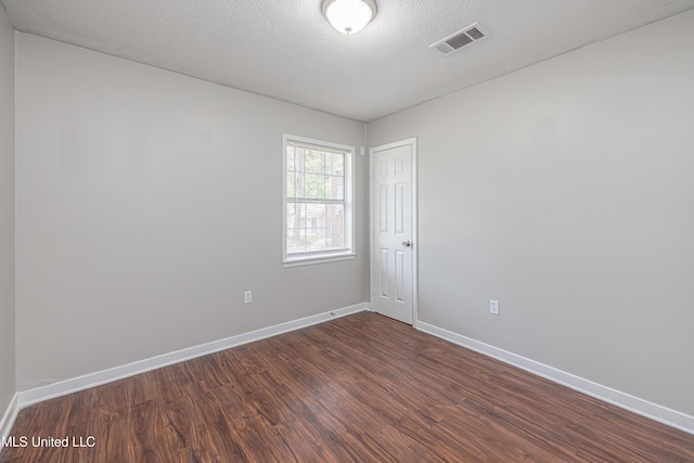 27 Wisteria Ct, Jackson, MS 39204 - empty room featuring dark wood-style floors, baseboards, and a textured ceiling