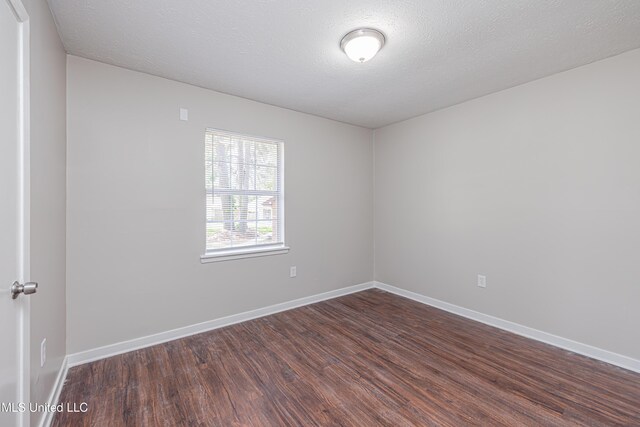 27 Wisteria Ct, Jackson, MS 39204 - spare room featuring dark wood finished floors, baseboards, and a textured ceiling