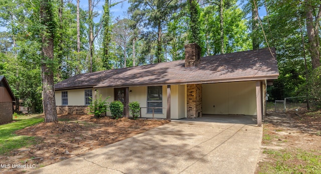 27 Wisteria Ct, Jackson, MS 39204 - view of front of home featuring concrete driveway, a chimney, an attached carport, and a shingled roof