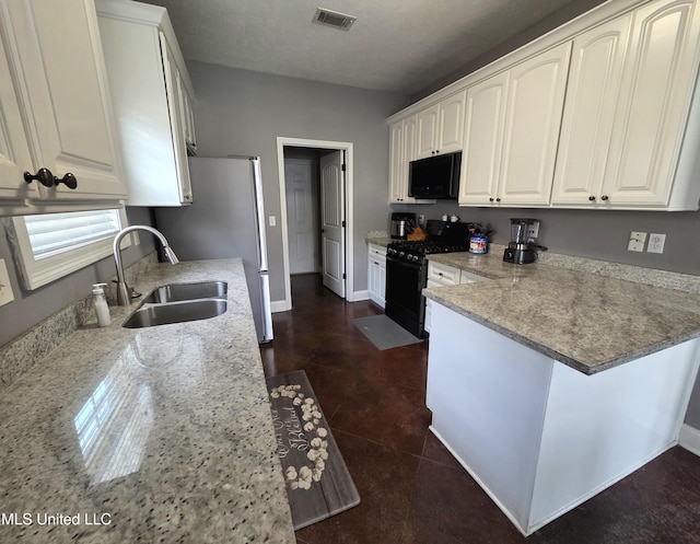 305 Flagstone Dr, Brandon, MS 39042 - kitchen with black appliances, a peninsula, white cabinetry, and light stone counters
