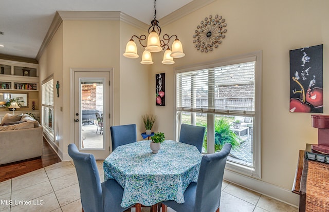 dining room featuring light tile patterned floors, ornamental molding, a chandelier, and baseboards