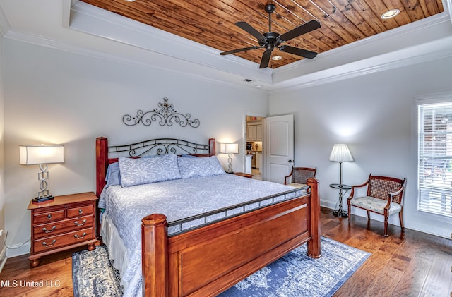 bedroom featuring a tray ceiling, hardwood / wood-style flooring, wood ceiling, and crown molding