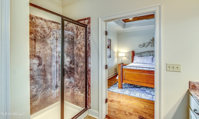 ensuite bathroom with a raised ceiling, ensuite bath, ornamental molding, wood finished floors, and a shower stall